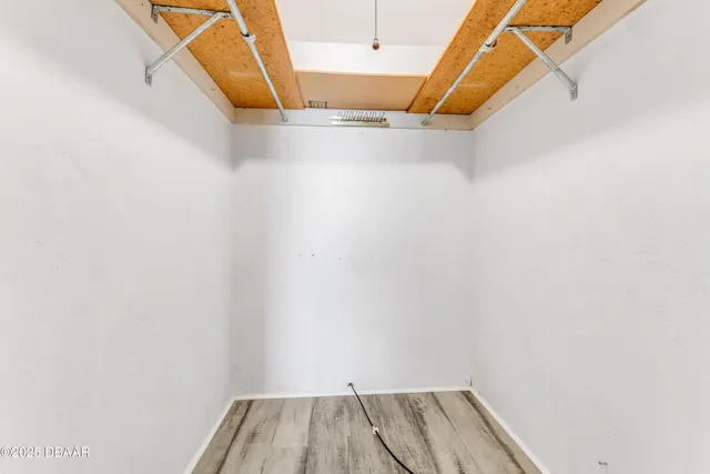 a view of walk in closet with clothes and white wooden door