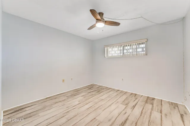 a view of a room with wooden floor and a ceiling fan