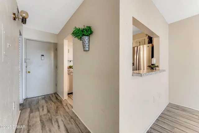 a view of a hallway with wooden floor and staircase