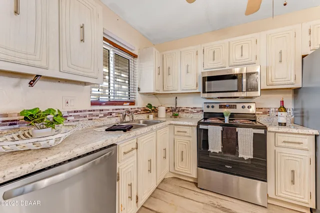 a kitchen with granite countertop white cabinets and white appliances