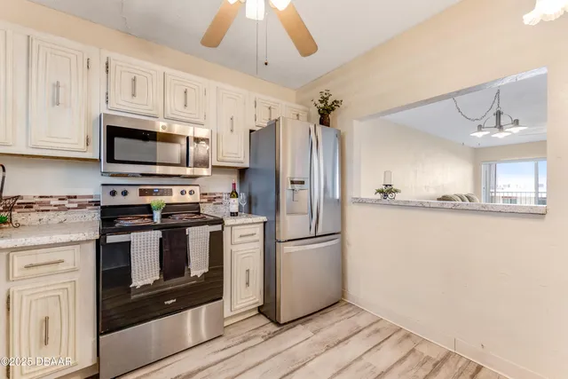 a kitchen with granite countertop a refrigerator stove and microwave