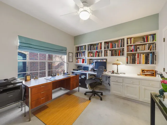a view of a workspace with furniture and a window