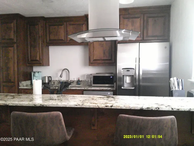 a kitchen with stainless steel appliances granite countertop a sink a stove and refrigerator