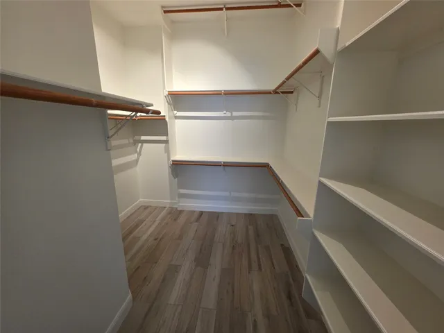 a view of walk in closet with wooden floor