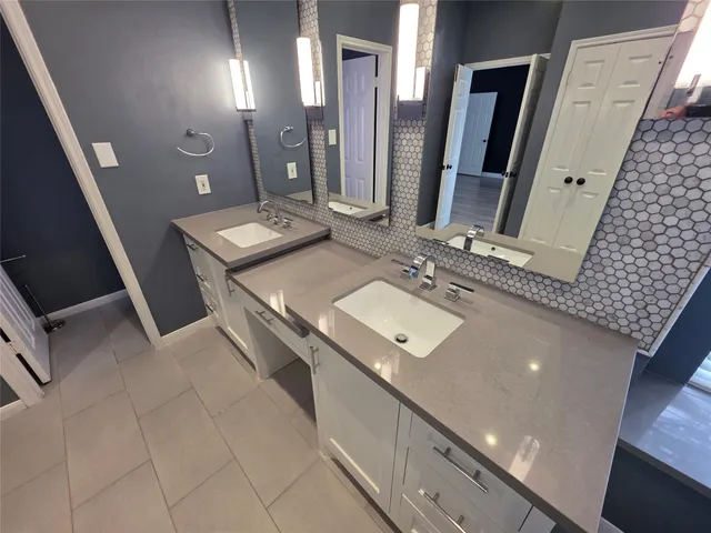 a bathroom with a double vanity sink a mirror and a toilet