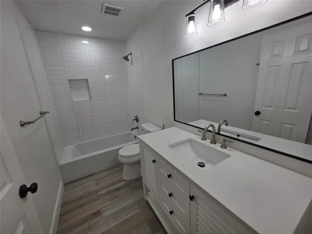 a bathroom with a double vanity sink toilet mirror and shower