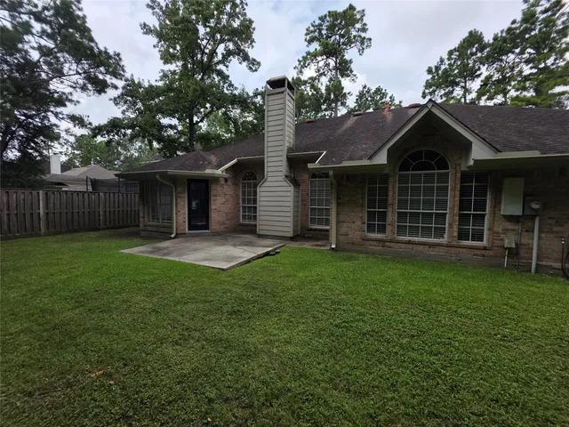a view of a backyard with a large tree and wooden fence