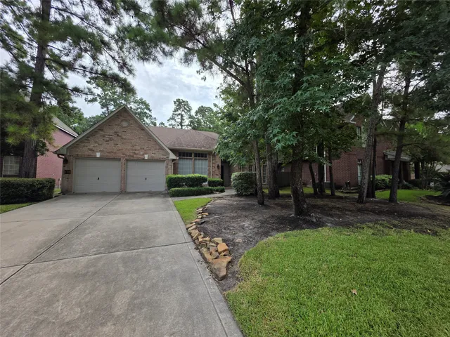 a front view of a house with a garden and trees