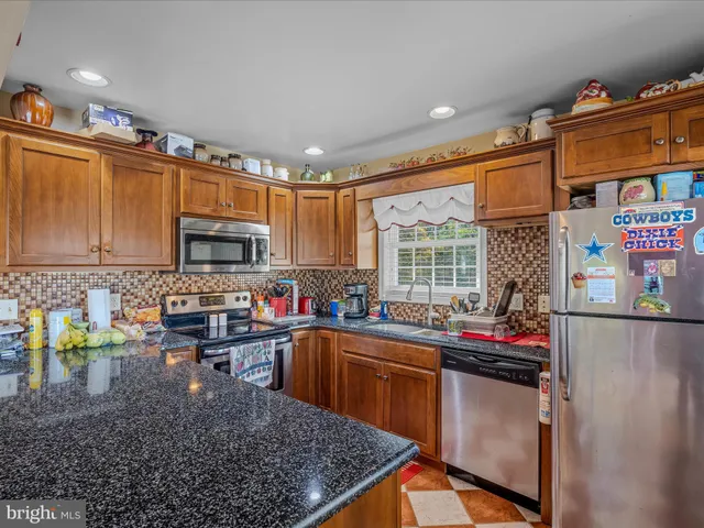 a kitchen with stainless steel appliances granite countertop a sink stove and cabinets