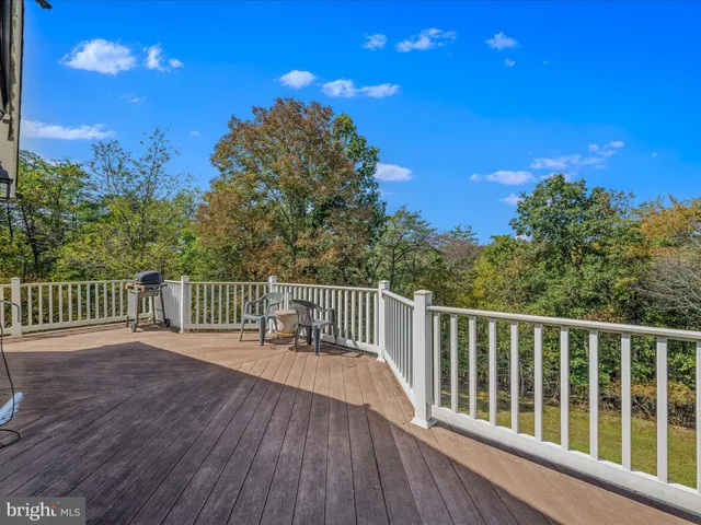 a balcony with wooden floor and trees in the background