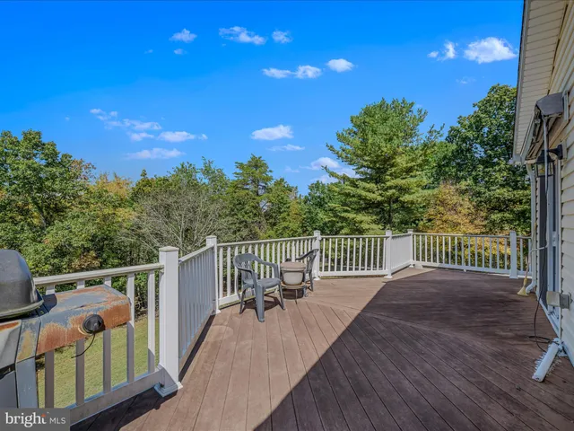 a view of a deck with a floor to ceiling window and wooden fence
