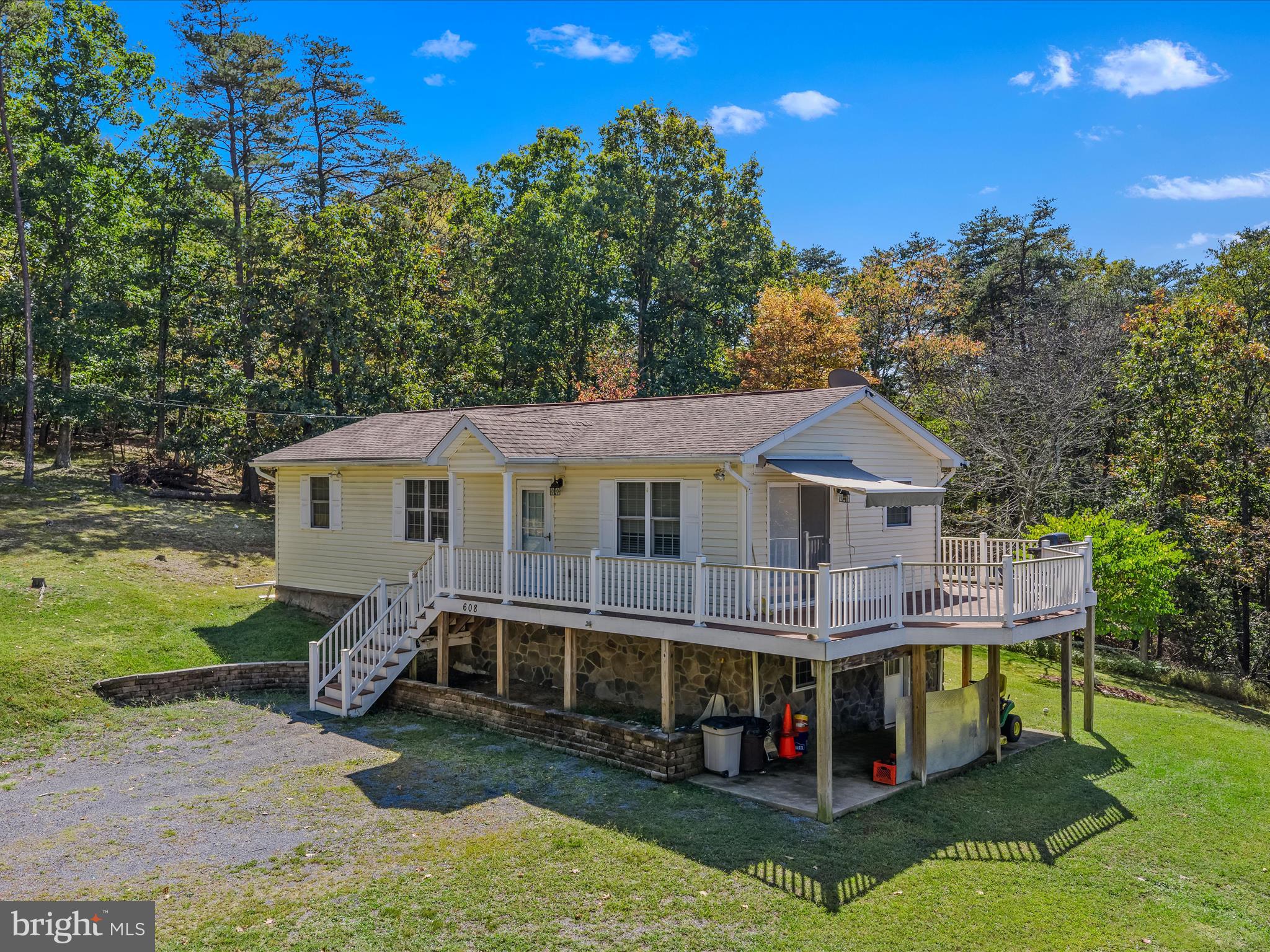 608 DeHaven Road Berkeley Springs, WV 25411 - Photo 3 of 52 a front view of a house with a yard table and chairs