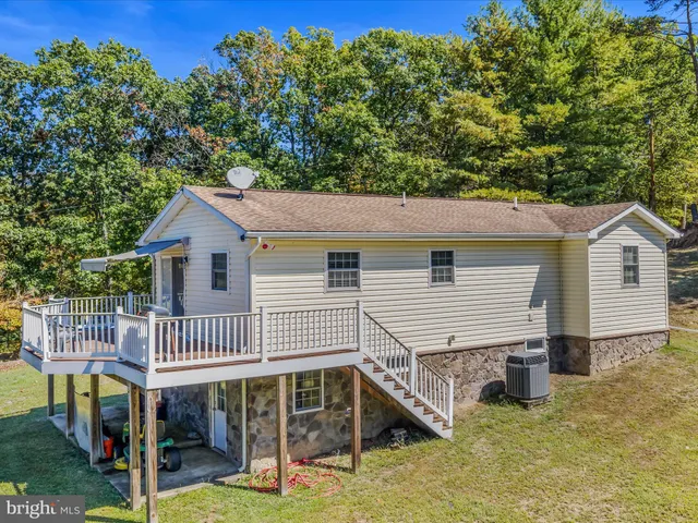 a view of a house with wooden deck and furniture