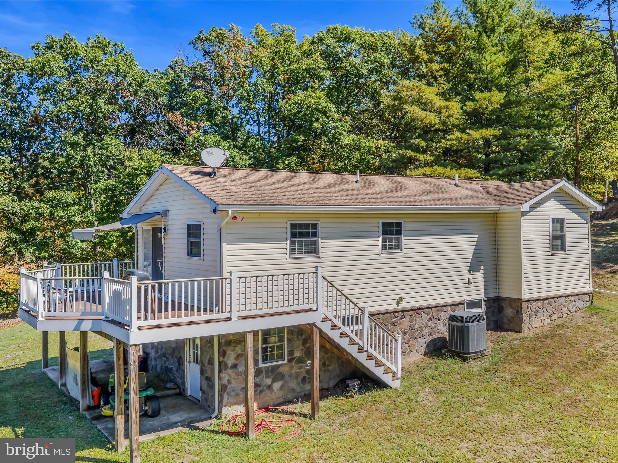 608 DeHaven Road Berkeley Springs, WV 25411 - Photo 33 of 52 a view of a house with wooden deck and furniture