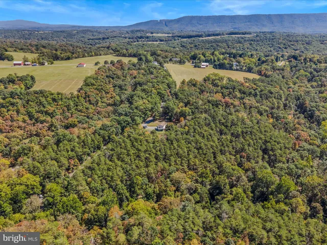 an aerial view of a houses with a lush green hillside