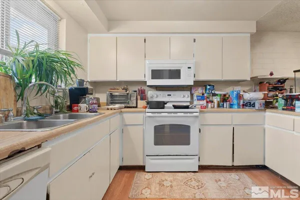 a kitchen with appliances a sink and cabinets