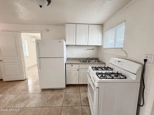 a kitchen with a stove a refrigerator and a sink