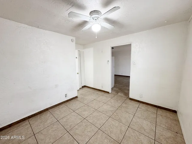 an empty room with windows and fan