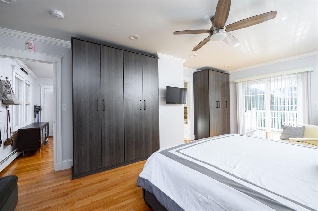 1099 Brook Road Milton, MA 02186 - Photo 19 of 41 a bedroom with a bed closet and wooden floor