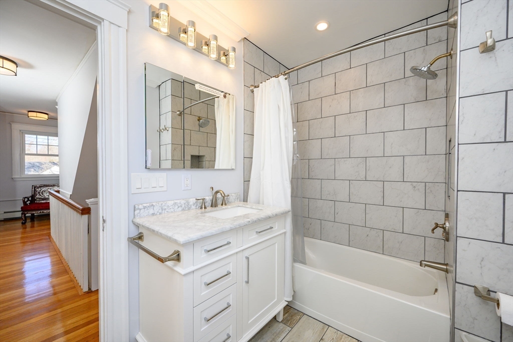 1099 Brook Road Milton, MA 02186 - Photo 29 of 41 a bathroom with a sink a mirror and a bathtub