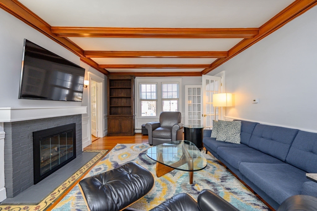 1099 Brook Road Milton, MA 02186 - Photo 3 of 41 a living room with furniture a flat screen tv and a fireplace