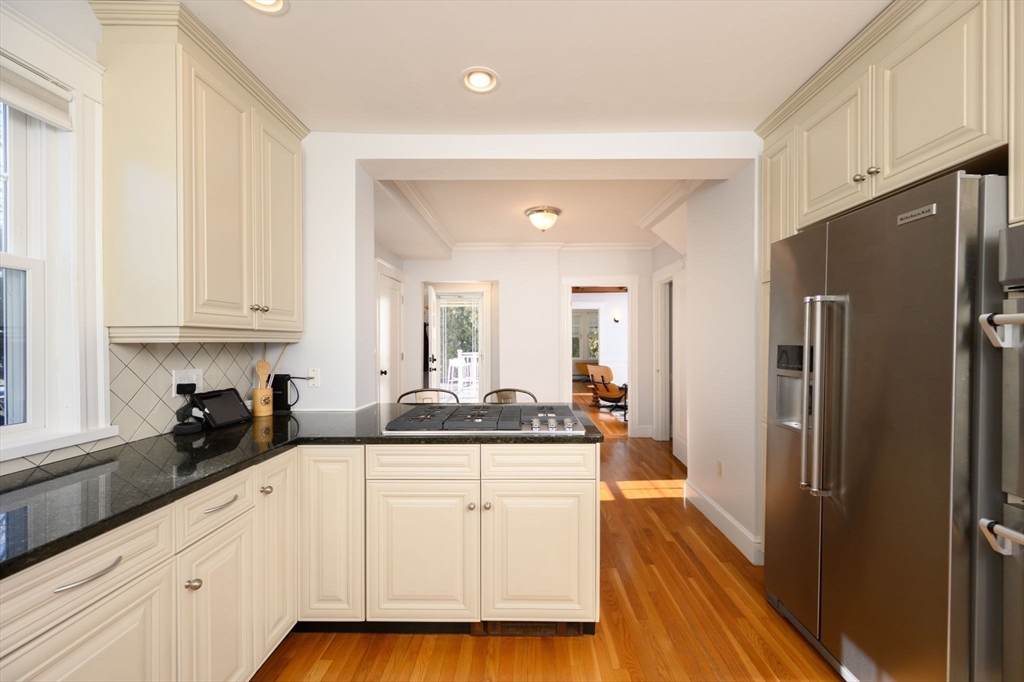 1099 Brook Road Milton, MA 02186 - Photo 9 of 41 a kitchen with stainless steel appliances granite countertop a refrigerator a sink and white cabinets with wooden floor