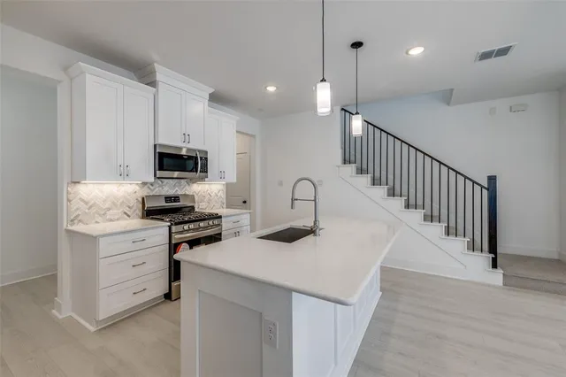 a kitchen with appliances a sink and cabinets