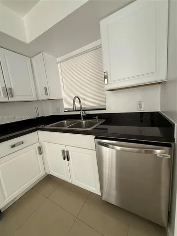 a kitchen with a refrigerator and a sink