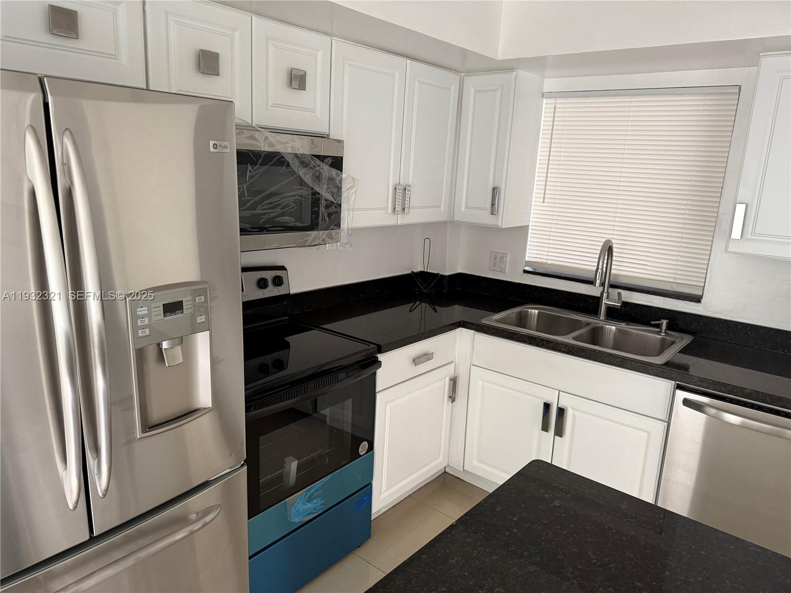 Arrowhead Condominium Davie, FL 33324 - Photo 23 of 35 a kitchen with a refrigerator and a sink