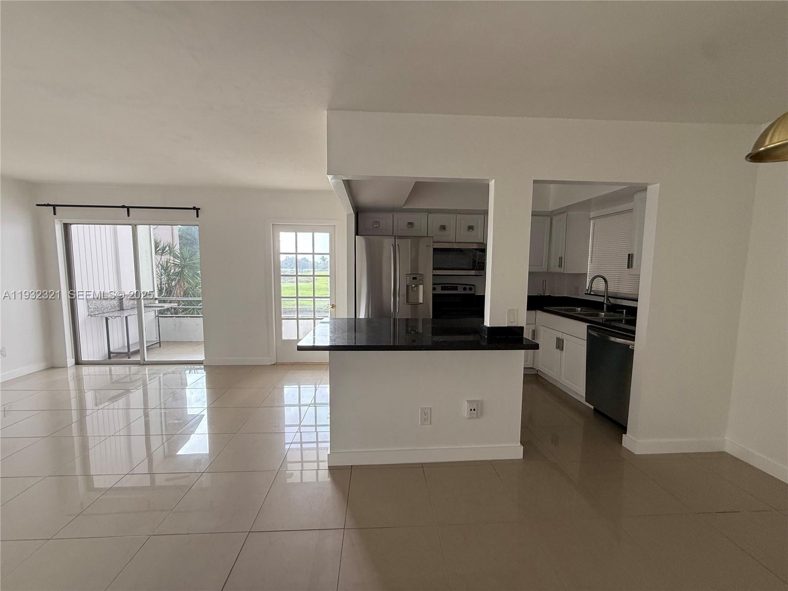 Arrowhead Condominium Davie, FL 33324 - Photo 30 of 35 a kitchen with granite countertop a stove a sink and a refrigerator