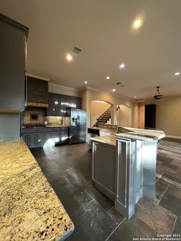 a kitchen with stainless steel appliances kitchen island granite countertop a refrigerator and stove