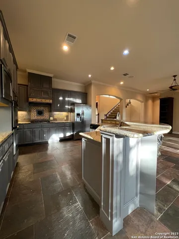a kitchen with stainless steel appliances granite countertop a refrigerator and a sink