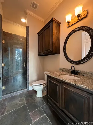 a bathroom with a granite countertop toilet a sink and a mirror