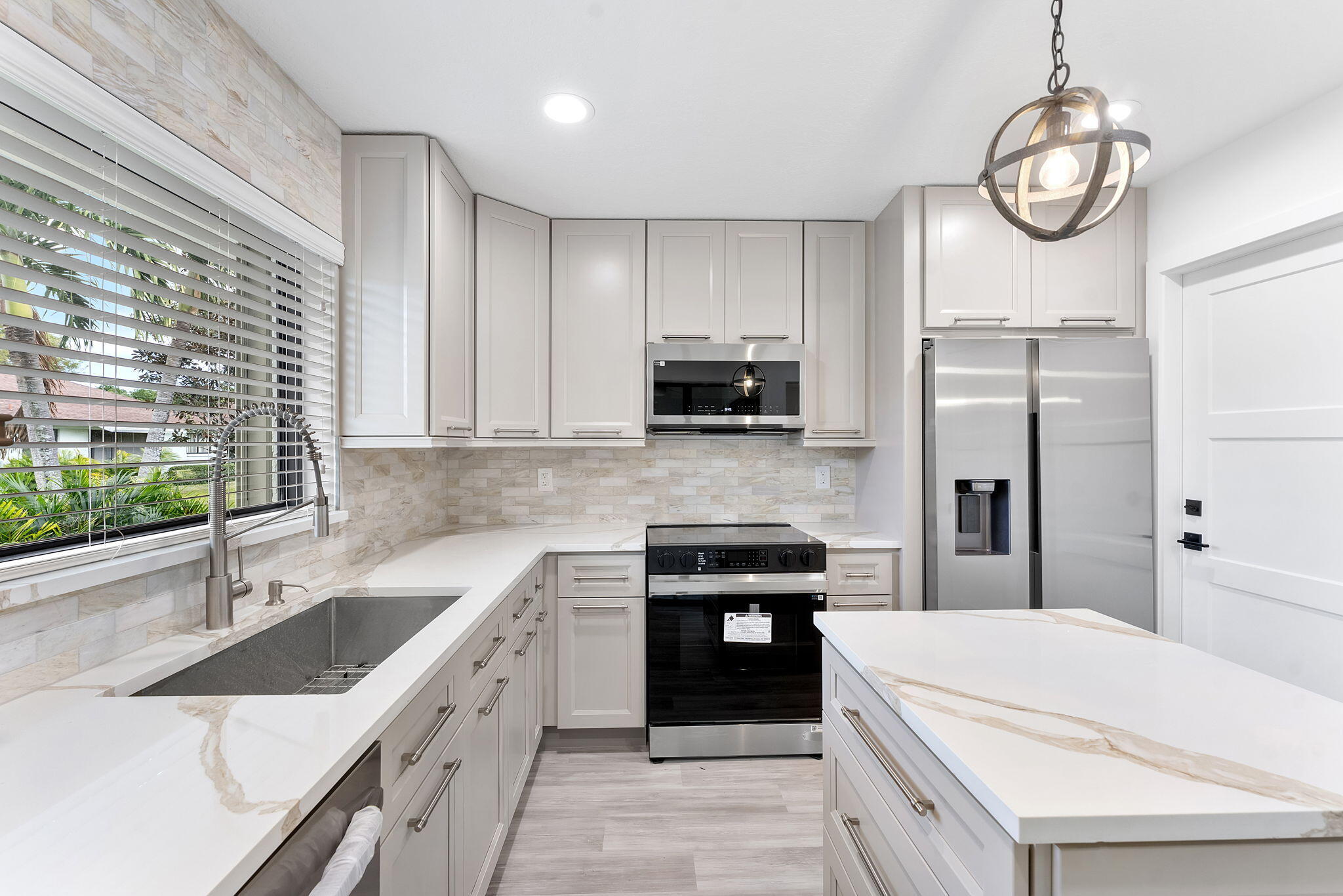 9840 Chestnut Tree Terrace, Unit A Boynton Beach, FL 33436 - Photo 11 of 27 a kitchen with stainless steel appliances granite countertop a sink a stove a refrigerator cabinets and a counter top space