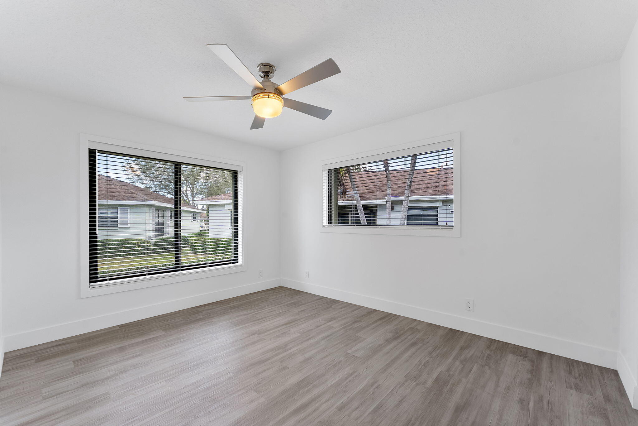 9840 Chestnut Tree Terrace, Unit A Boynton Beach, FL 33436 - Photo 16 of 27 a view of an empty room with a window and wooden floor