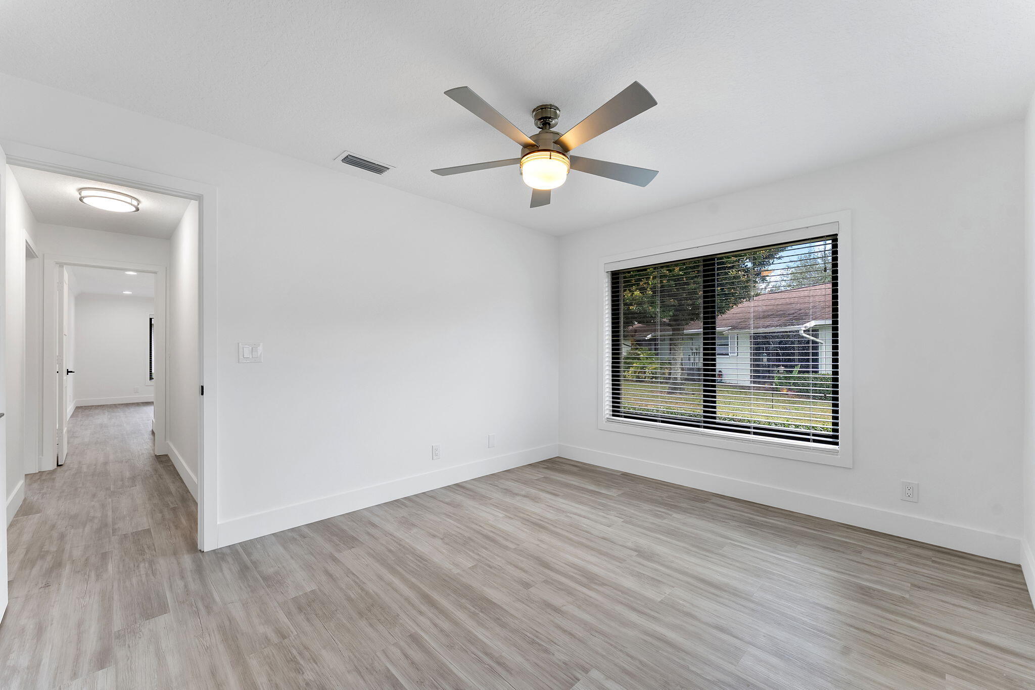 9840 Chestnut Tree Terrace, Unit A Boynton Beach, FL 33436 - Photo 17 of 27 a view of an empty room with wooden floor and a window