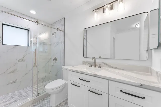 a bathroom with a sink a toilet and shower