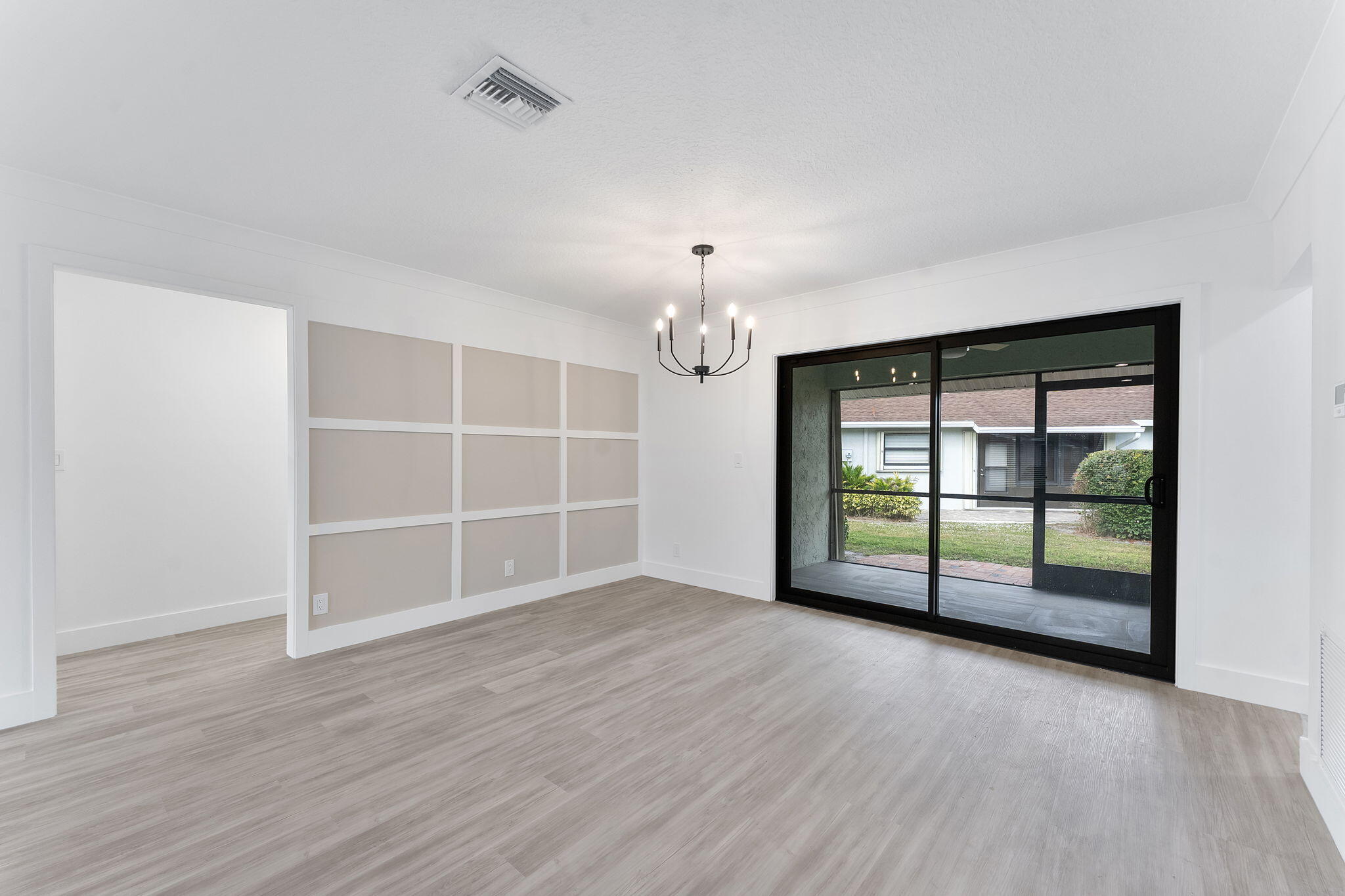 9840 Chestnut Tree Terrace, Unit A Boynton Beach, FL 33436 - Photo 26 of 27 an empty room with wooden floor and windows