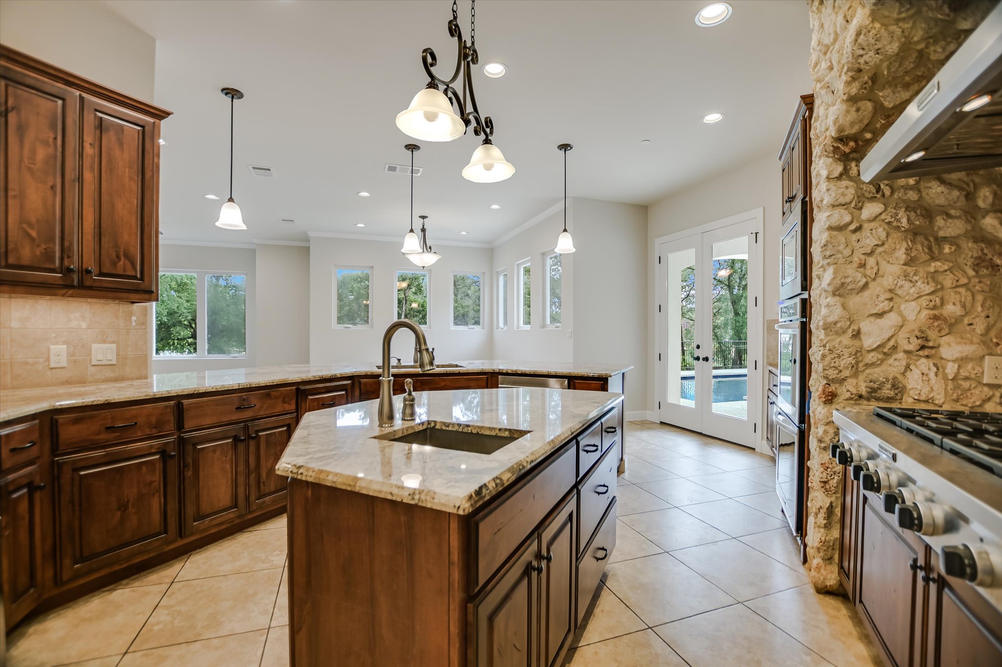 11 Inwood Circle Austin, TX 78746 - Photo 14 of 38 An open kitchen with granite countertops, rich wood cabinetry, and sleek tile flooring.