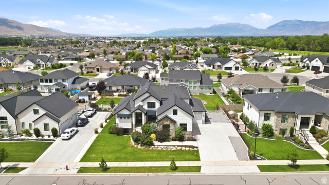 1002 West Temple Rim Lane Payson, UT 84651 - Photo 4 of 68 Modern residence featuring a dark roof, white siding, and stone accents
