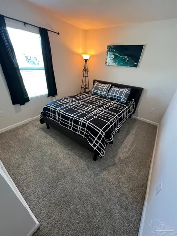 a bedroom with a bed and a flat tv screen on dresser
