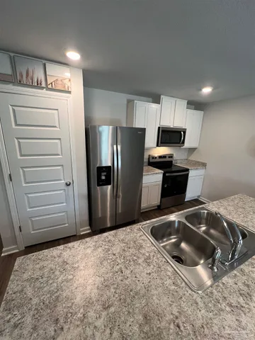 a kitchen with stainless steel appliances granite countertop a refrigerator and a stove