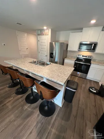 a kitchen with stainless steel appliances wooden floors wooden cabinets and wooden floor