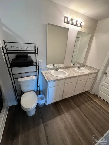 a bathroom with a sink mirror vanity and toilet