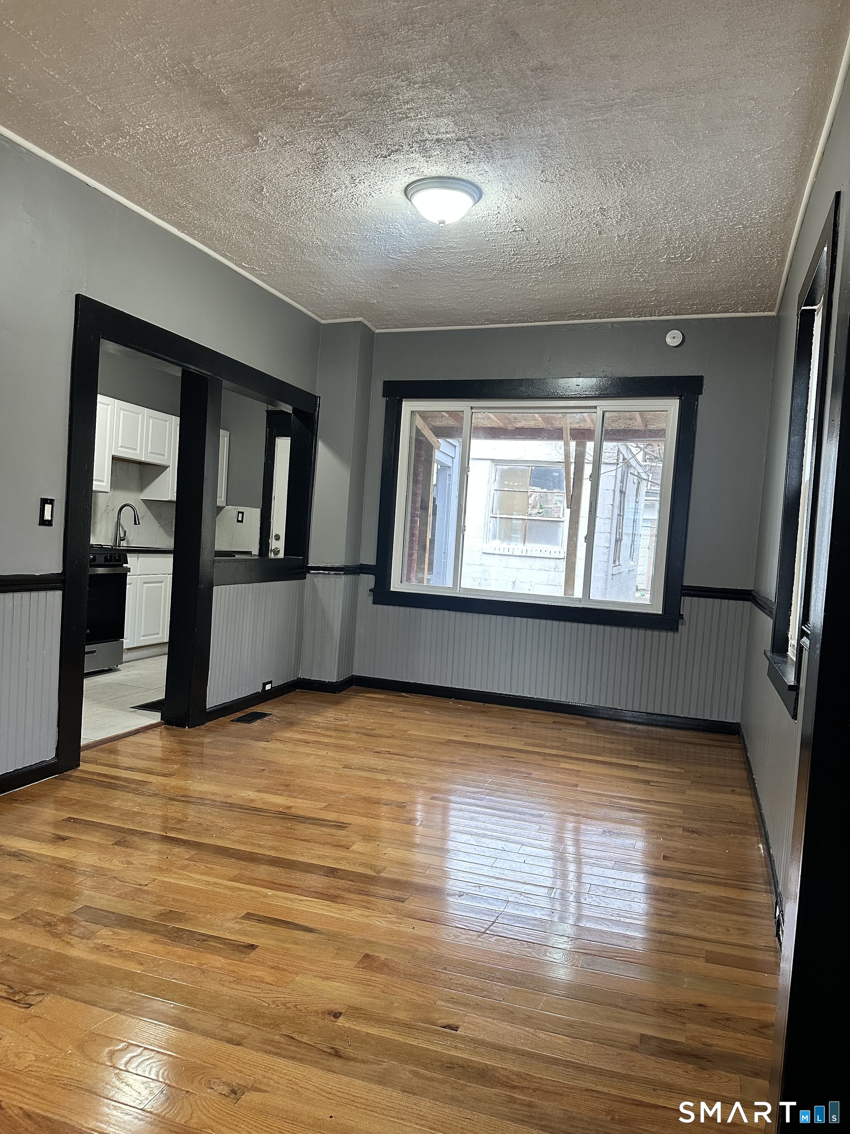 302 Dover Street Bridgeport, CT 06610 - Photo 4 of 40 a view of an empty room with window and wooden floor