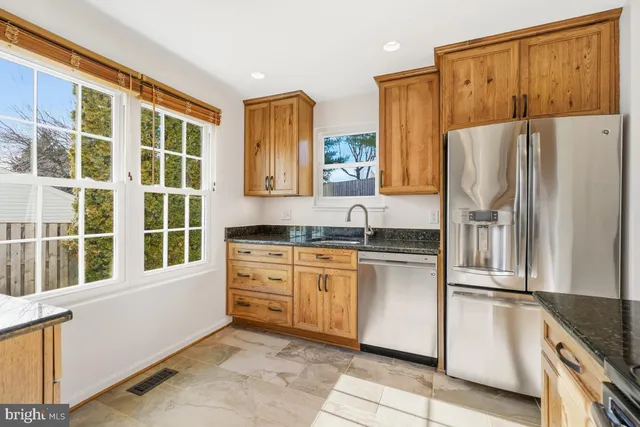 a kitchen with stainless steel appliances granite countertop a refrigerator and a sink