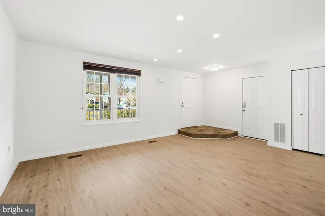 wooden floor in an empty room with a window