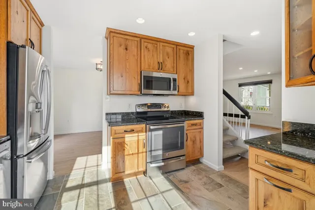 a kitchen with stainless steel appliances granite countertop a stove a sink and a refrigerator