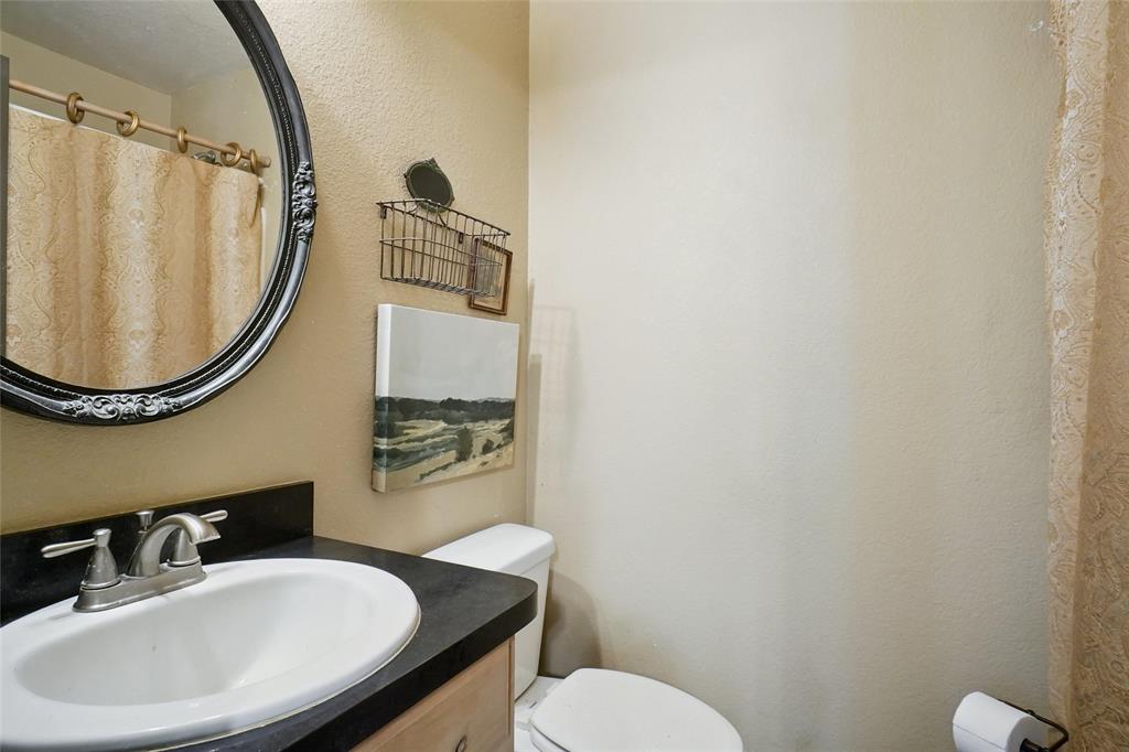 2454 Decatur Tx 76234 Decatur, TX 76234 - Photo 17 of 35 a bathroom with a sink a mirror and a toilet