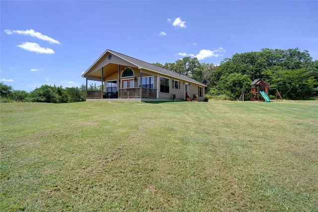 a house with huge green field in front of it